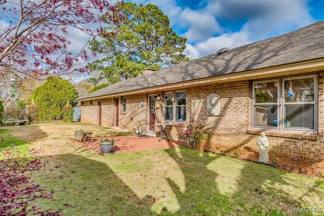 back of house with a yard and a patio