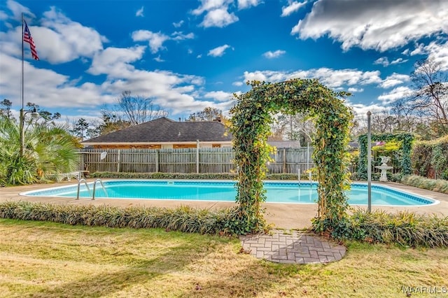 view of swimming pool with a yard