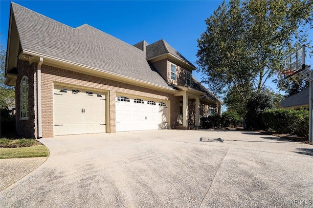 156 Walnut Point Dr, Wetumpka, AL 36093 - view of property exterior with driveway, a shingled roof, an attached garage, and brick siding