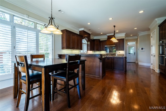 dining room with sink, crown molding, and dark hardwood / wood-style flooring