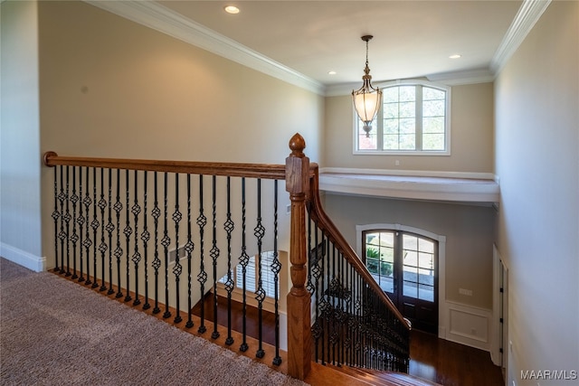 stairs featuring french doors, a healthy amount of sunlight, wood-type flooring, and ornamental molding