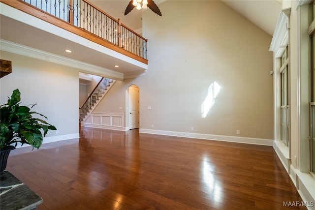 unfurnished living room featuring high vaulted ceiling, dark wood-type flooring, and ceiling fan