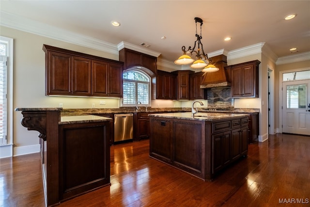 kitchen with a kitchen island with sink, dark hardwood / wood-style floors, pendant lighting, appliances with stainless steel finishes, and light stone counters