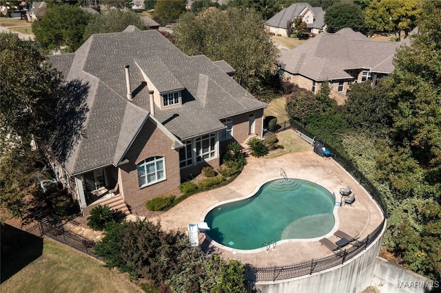 view of swimming pool featuring a patio and a diving board