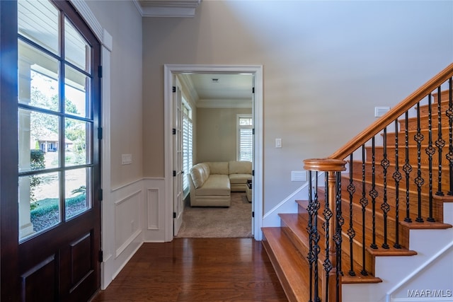 entryway with crown molding, a healthy amount of sunlight, and dark wood-type flooring