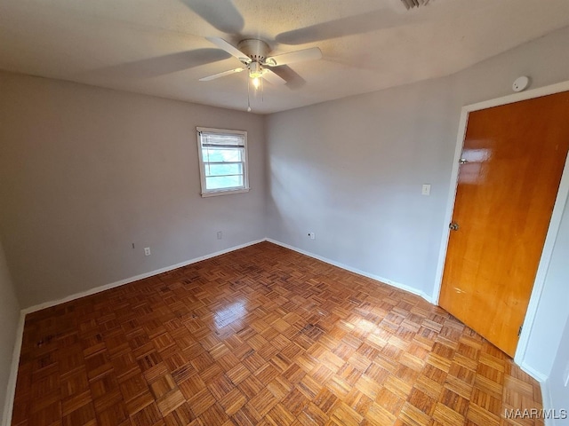 unfurnished room with ceiling fan and parquet floors