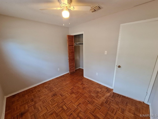 unfurnished bedroom featuring dark parquet flooring and ceiling fan