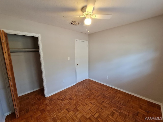 unfurnished bedroom with baseboards, visible vents, a ceiling fan, and a closet