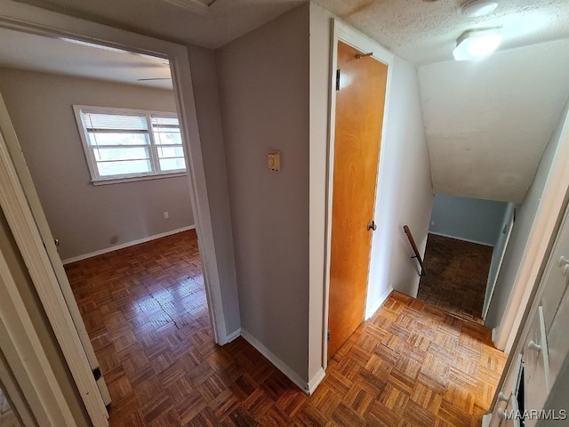 hall with a textured ceiling and dark parquet flooring