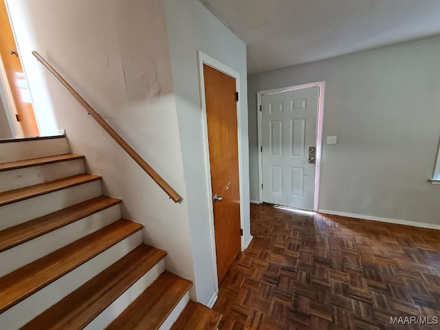 stairway featuring parquet floors