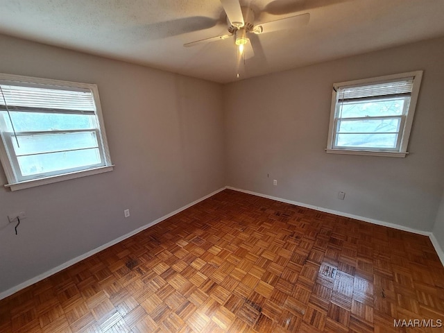 spare room featuring a ceiling fan and baseboards