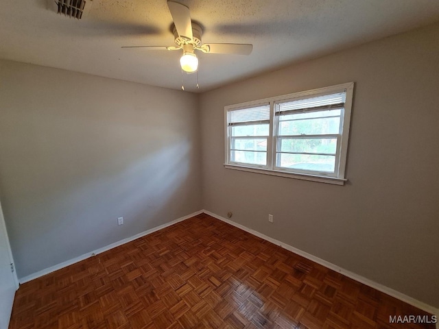 spare room featuring visible vents, ceiling fan, and baseboards