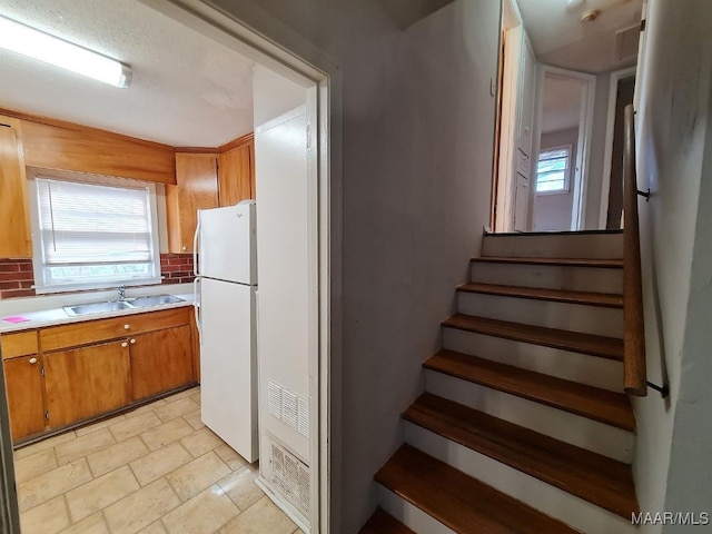 stairway featuring stone tile floors
