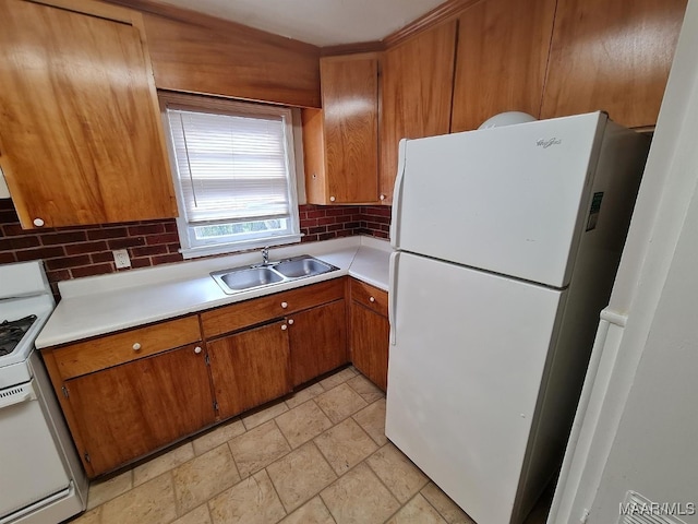 kitchen featuring white appliances, light countertops, brown cabinets, backsplash, and a sink