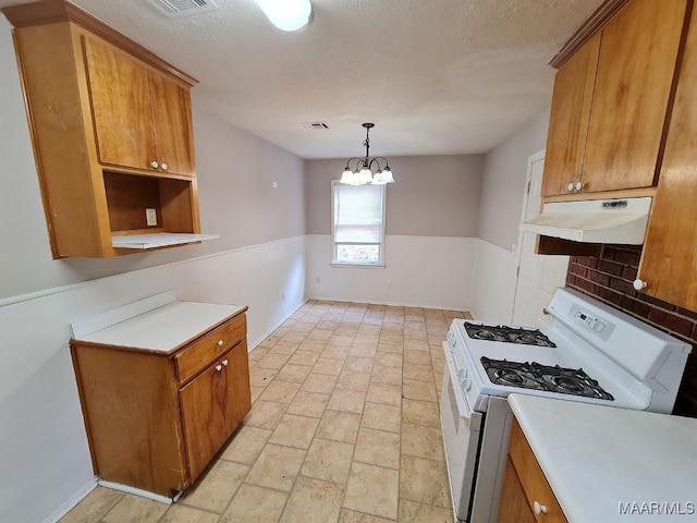 kitchen featuring decorative backsplash, hanging light fixtures, gas range gas stove, an inviting chandelier, and a textured ceiling