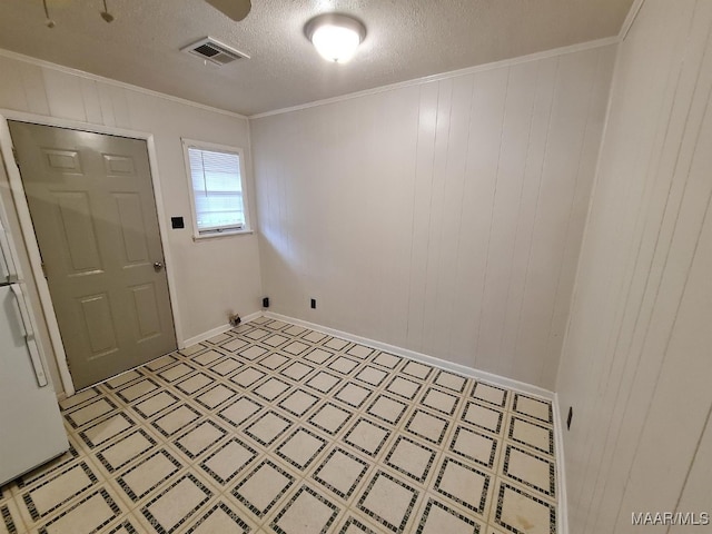 interior space featuring crown molding, a textured ceiling, and wooden walls