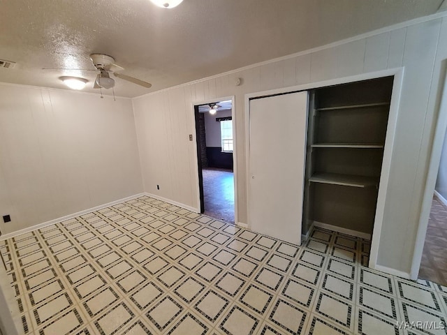 interior space with a closet, ceiling fan, crown molding, and a textured ceiling