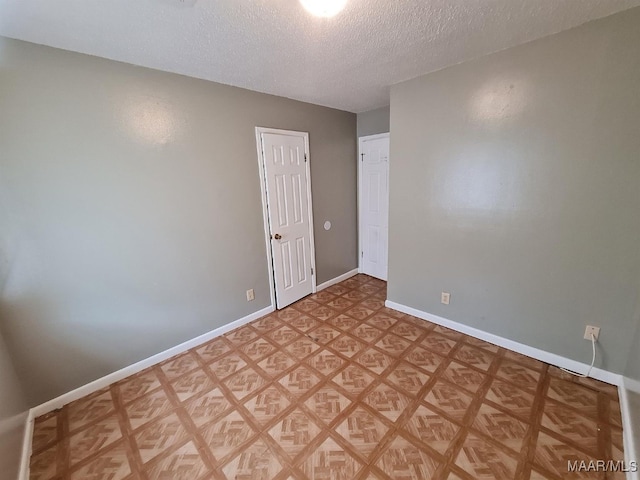 empty room featuring a textured ceiling and light parquet flooring