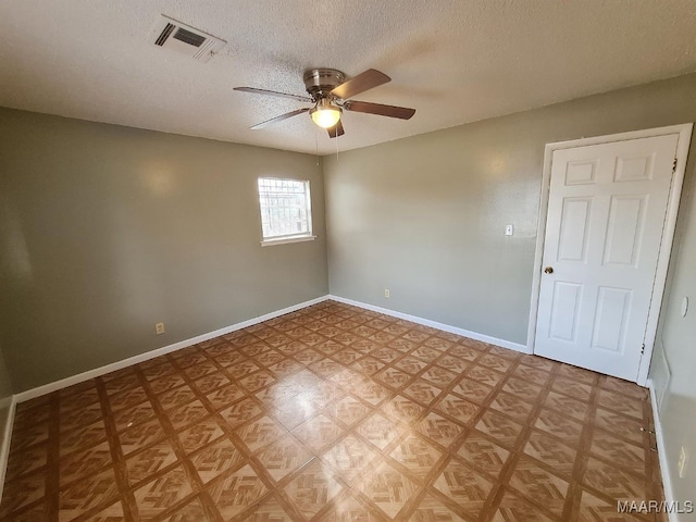 spare room with a textured ceiling and ceiling fan