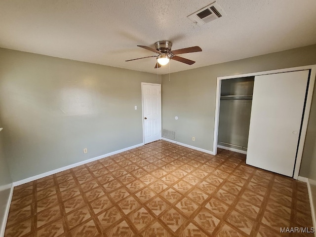 unfurnished bedroom with a closet, a textured ceiling, light parquet floors, and ceiling fan