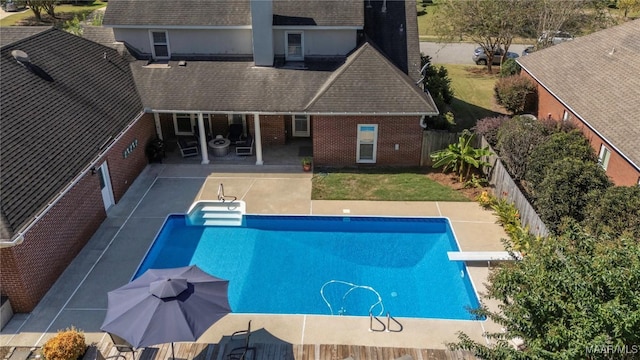 view of swimming pool featuring a fenced backyard, a diving board, a fenced in pool, and a patio