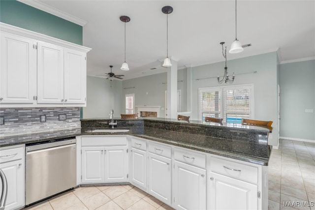 kitchen with light tile patterned floors, a sink, stainless steel dishwasher, decorative backsplash, and crown molding