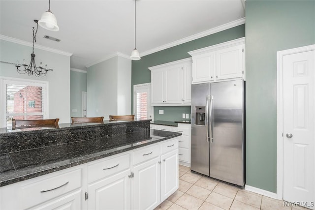 kitchen featuring hanging light fixtures, light tile patterned floors, stainless steel fridge, and white cabinets