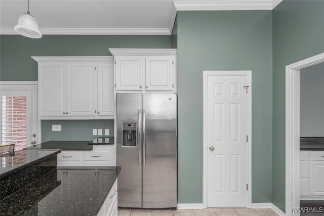 kitchen featuring white cabinetry, hanging light fixtures, ornamental molding, dark stone counters, and stainless steel fridge