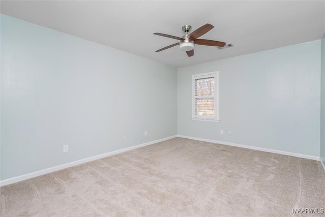 empty room with carpet floors, visible vents, baseboards, and a ceiling fan