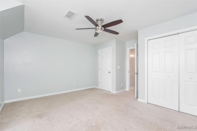 unfurnished bedroom featuring a ceiling fan, light colored carpet, visible vents, and baseboards