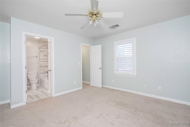 unfurnished bedroom with a ceiling fan, visible vents, baseboards, carpet, and ensuite bath