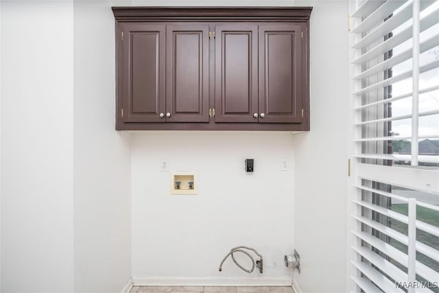 clothes washing area featuring washer hookup, hookup for a gas dryer, cabinet space, electric dryer hookup, and baseboards