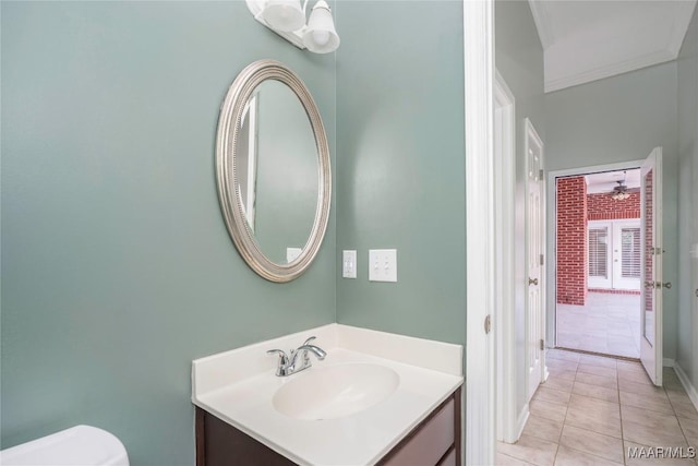 bathroom featuring toilet, crown molding, vanity, and tile patterned floors