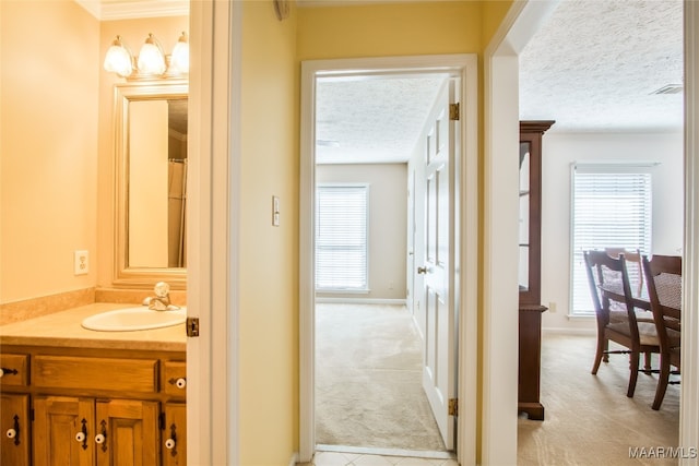 bathroom with vanity, a textured ceiling, and ornamental molding