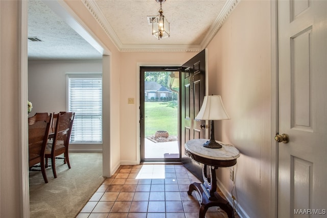 entryway featuring a textured ceiling, ornamental molding, and tile patterned flooring