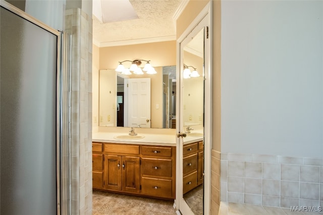 bathroom with vanity, crown molding, a textured ceiling, and walk in shower