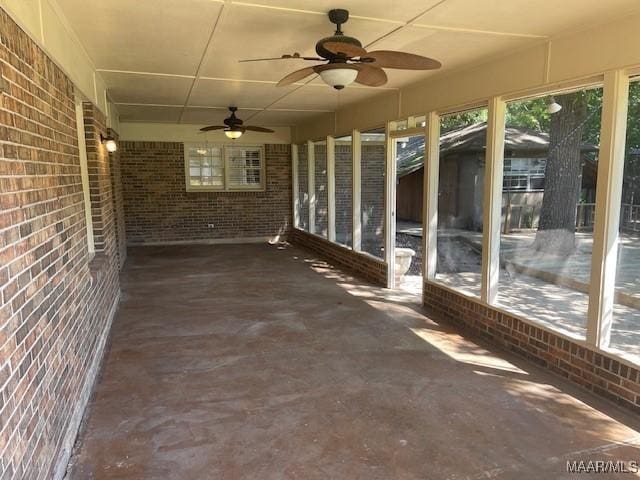 unfurnished sunroom with a ceiling fan