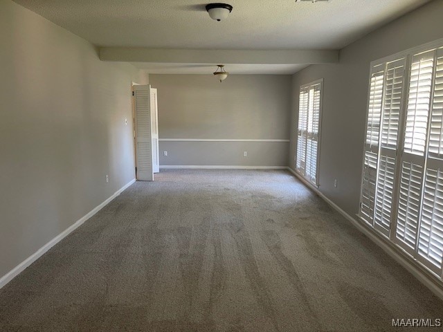 carpeted empty room with a textured ceiling