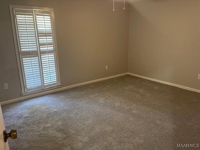 carpeted spare room with baseboards