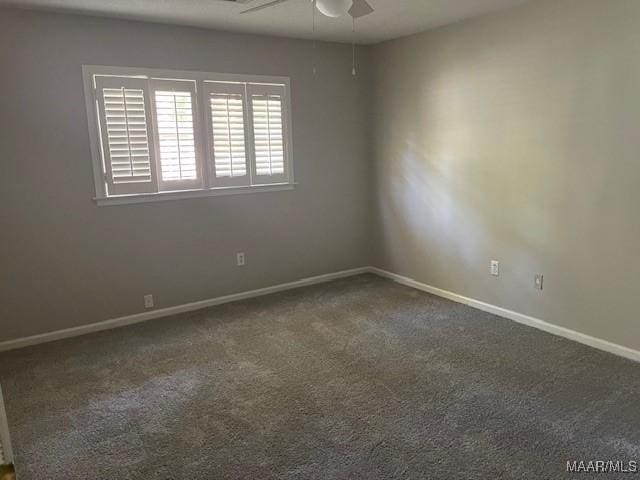 carpeted empty room featuring a ceiling fan and baseboards