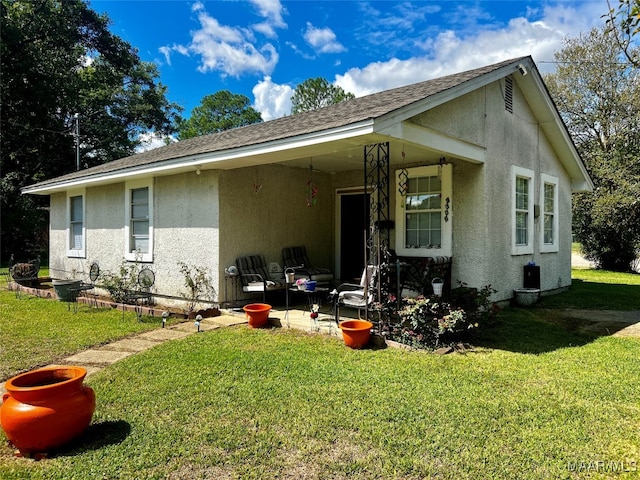 back of house featuring a patio area and a yard