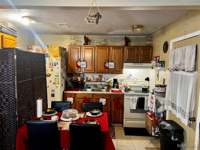 kitchen featuring light tile patterned flooring, sink, electric stove, a textured ceiling, and black refrigerator