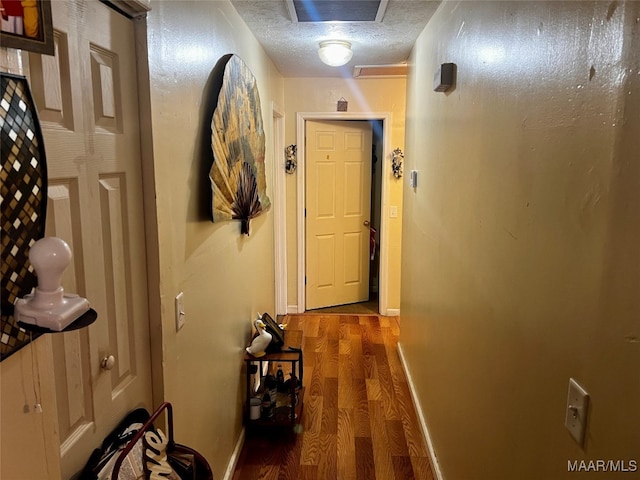 hallway featuring hardwood / wood-style flooring and a textured ceiling