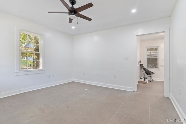 tiled spare room featuring ceiling fan