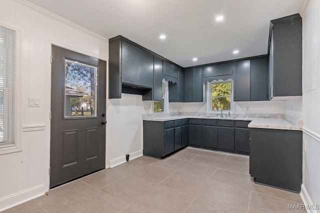 kitchen featuring crown molding, sink, and light tile patterned floors