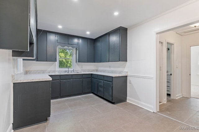 kitchen with ornamental molding, light tile patterned flooring, and sink