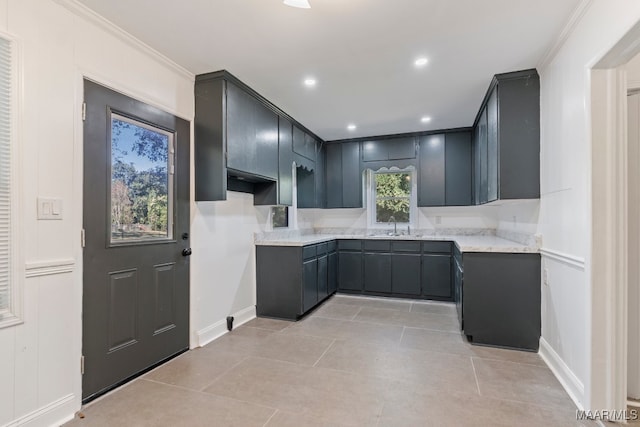 kitchen with ornamental molding, sink, and light tile patterned floors