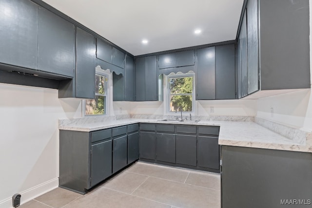 kitchen featuring gray cabinets, sink, and light tile patterned flooring