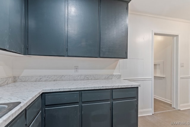 kitchen with crown molding, light stone countertops, light tile patterned floors, and gray cabinets