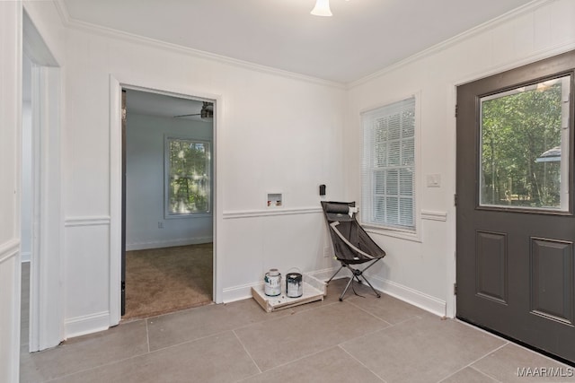 doorway with ornamental molding, ceiling fan, and light tile patterned floors